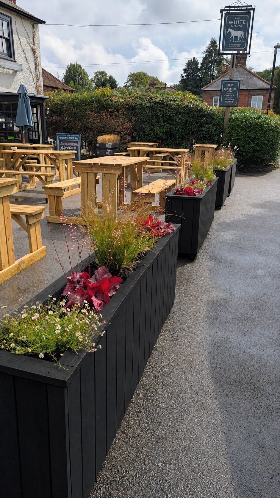A run of planted troughs alongside the picnic benches at The White Horse